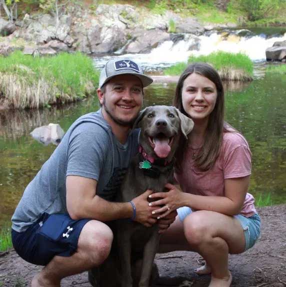 Doctor Zach Bruley, his wife and his dog outside.
