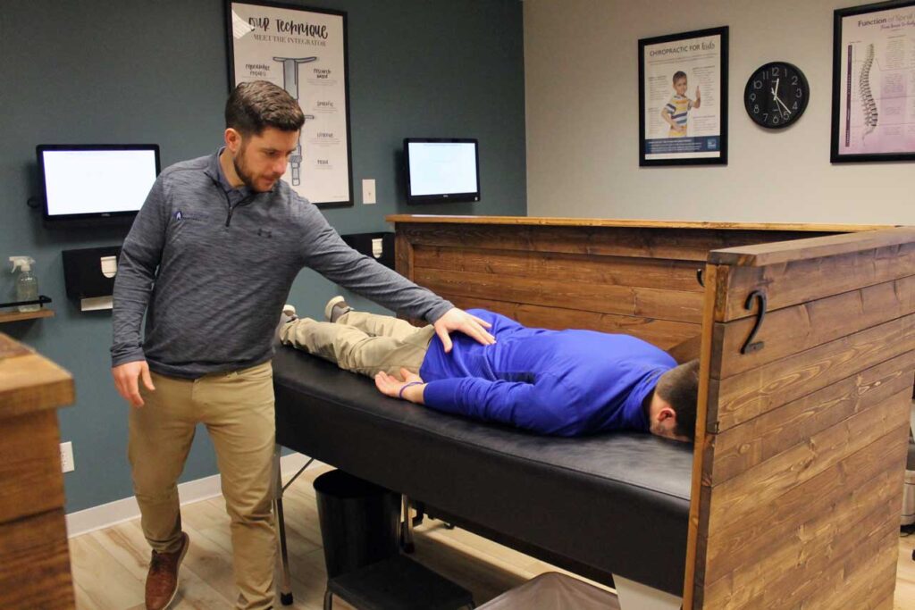 Doctor Evan Norum of Advantage Chiropractic in New Berlin, WI, examines a chiropractic care clinic patient.