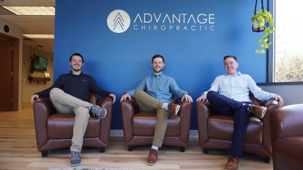 ADVANTAGE CHIROPRACTIC Back Pain chiropractors sitting on a couch posing in New Berlin, WI.