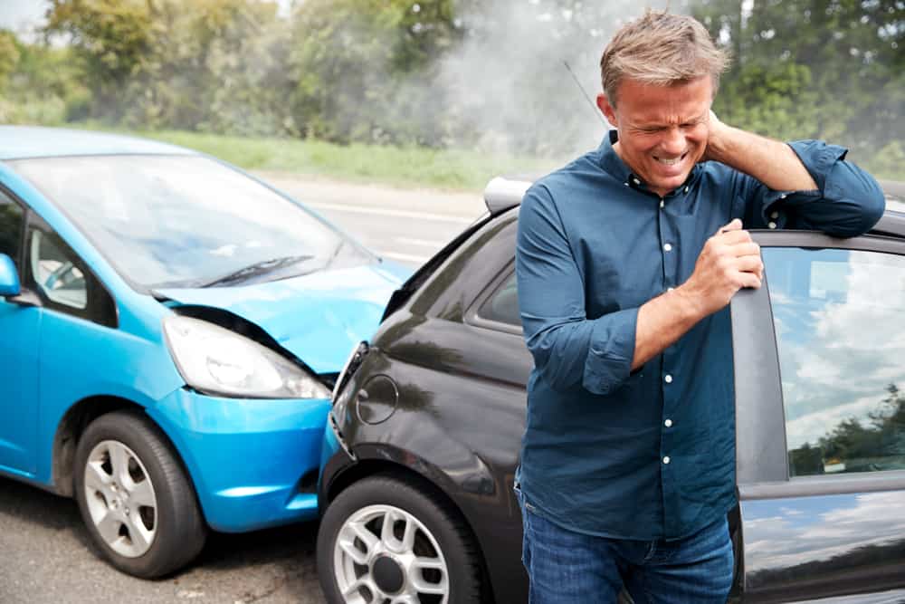 man holding neck after car accident.