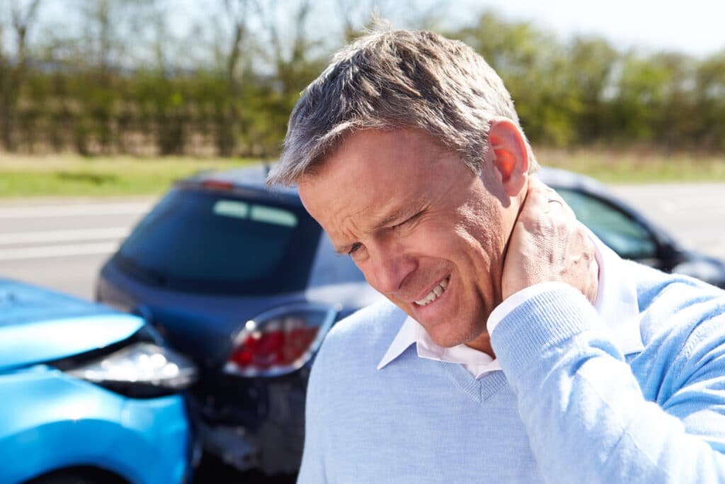 patient holding neck after whiplash injury in a car accident.