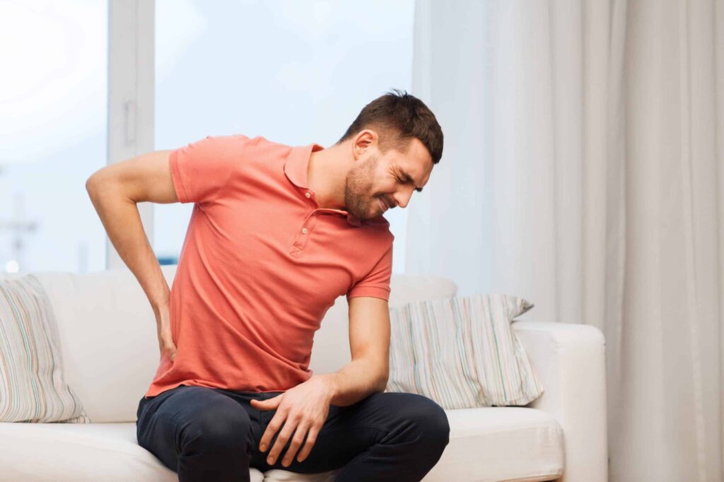 Man holding holding his back in pain.