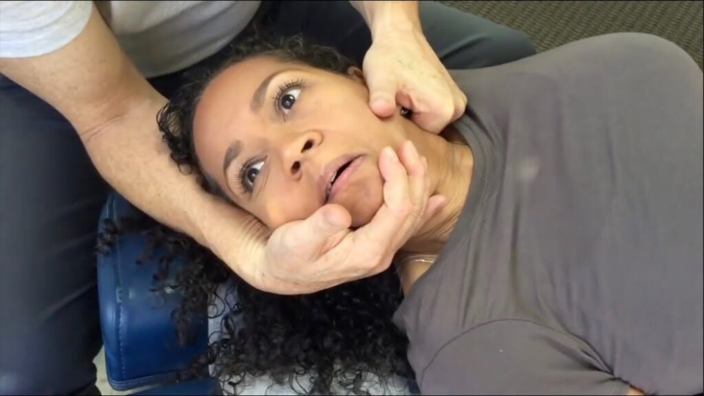Patient getting neck twisted by a chiropractor.