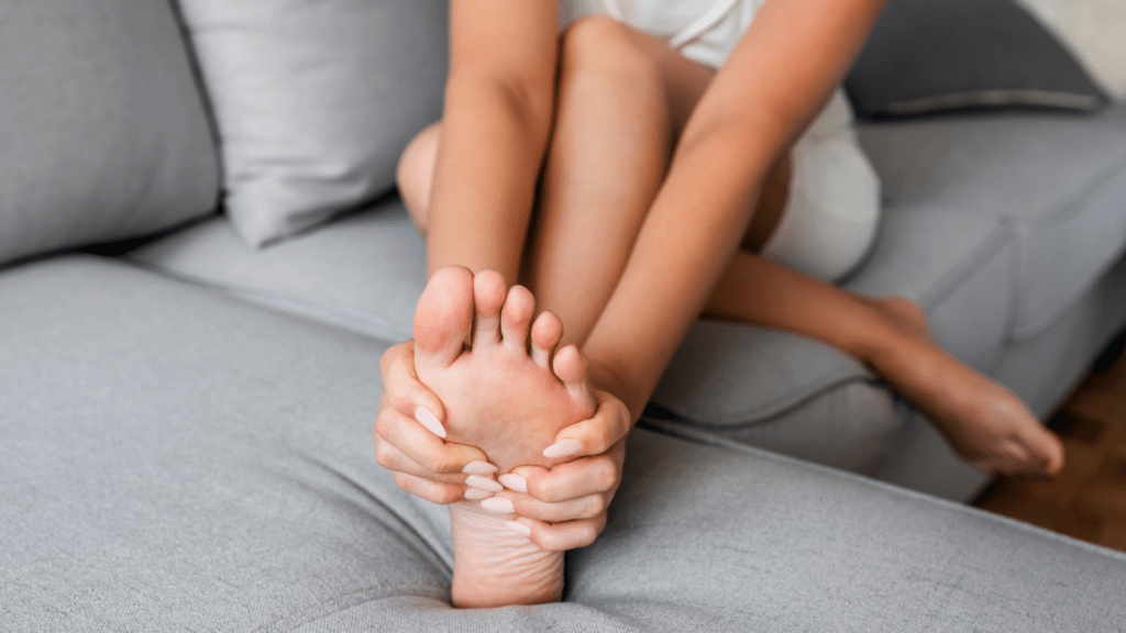 woman holding foot in pain from neuropathy