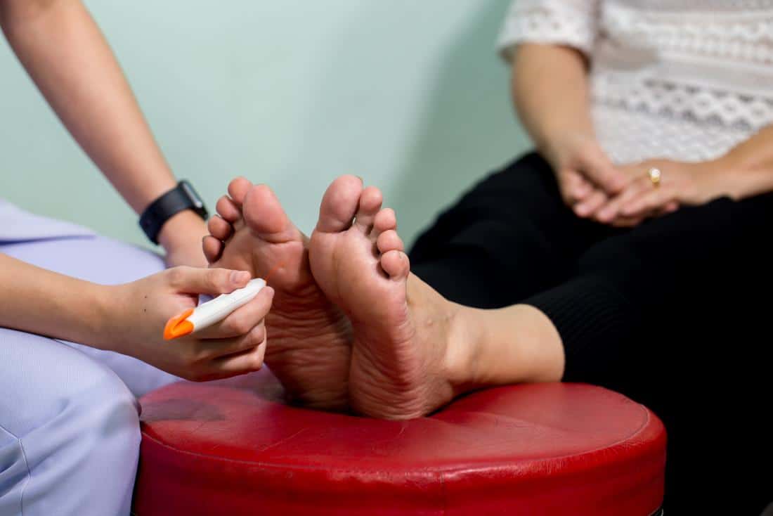 Woman's foot getting tested for peripheral neuropathy.