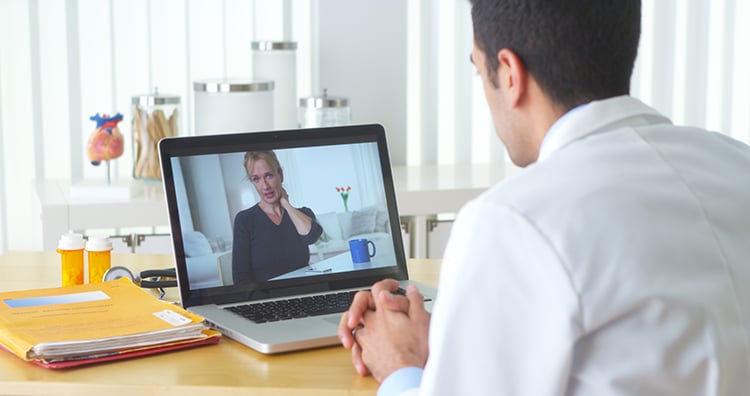 Chiropractor visiting patient over video chat.