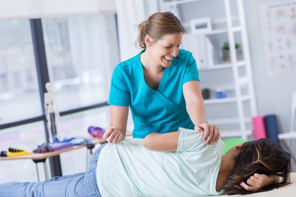 chiropractor adjusting a patients spine in a medical office.
