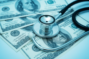Chiropractor stethoscope and money indicating the cost of a chiropractor.