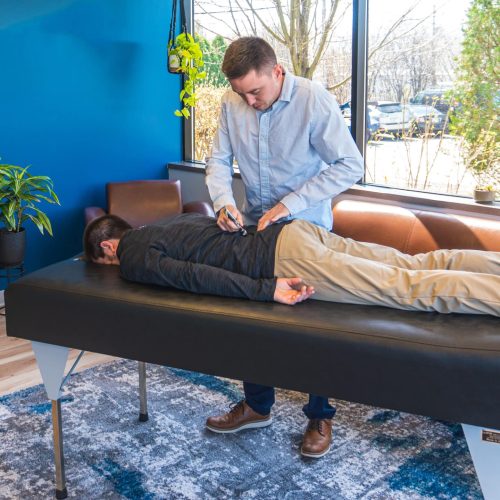 Chiropractor in New Berlin, WI performing a chiropractic adjustment on a patient.